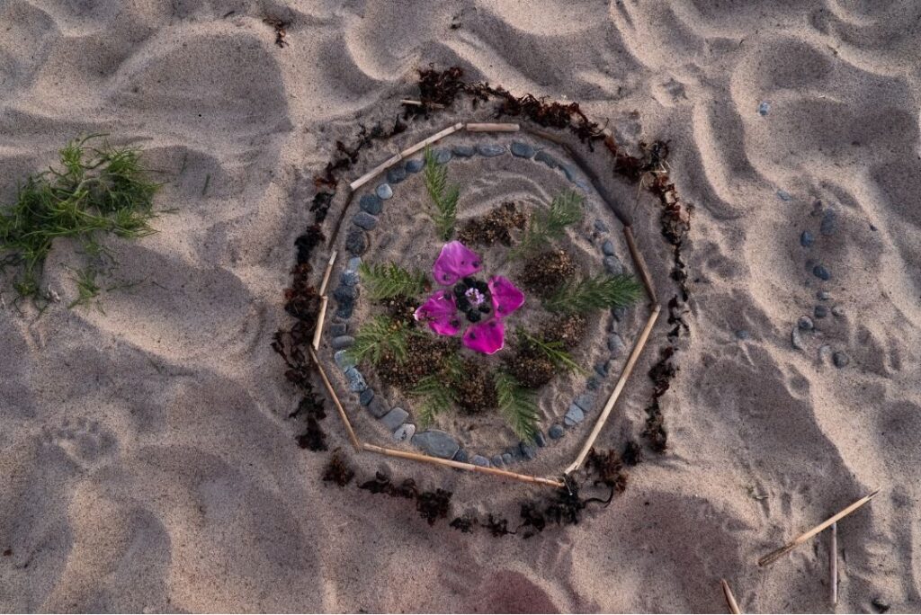 A grief mandala on a beach